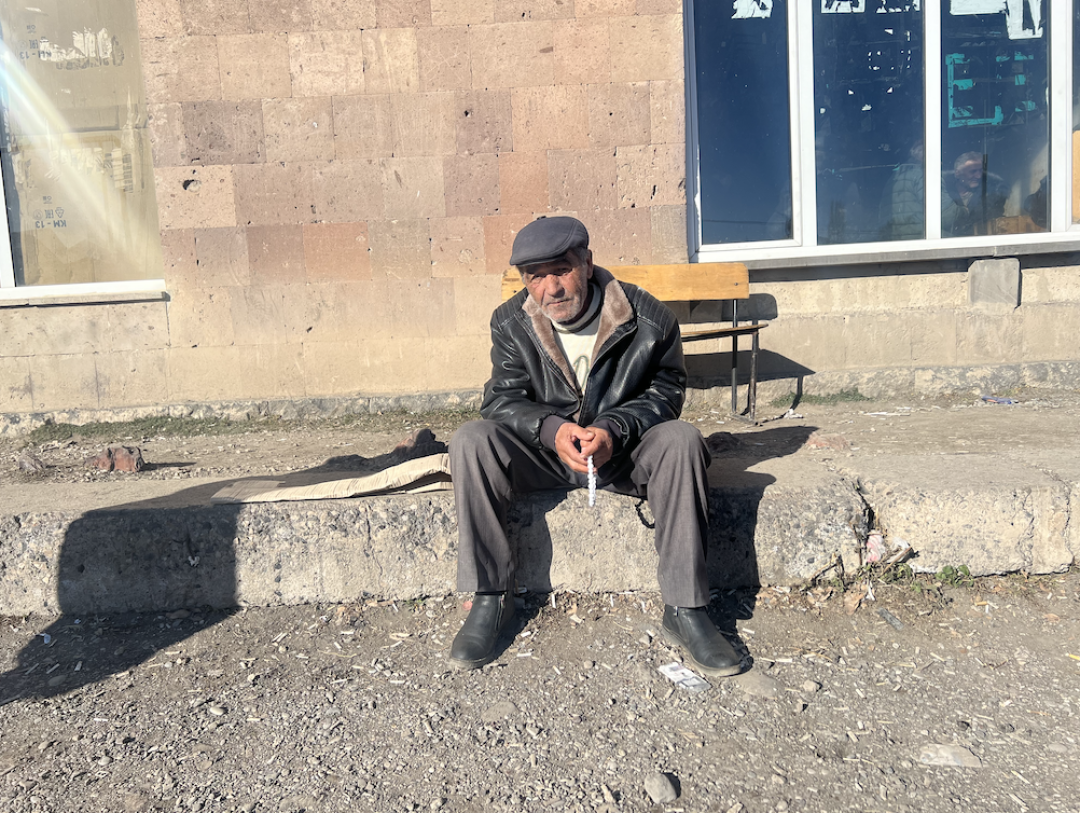 Gagik Petrosyan sitting in front of the Culture house in Khachaghbyur